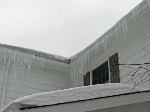 Ice dam and icicles on edge of roof.